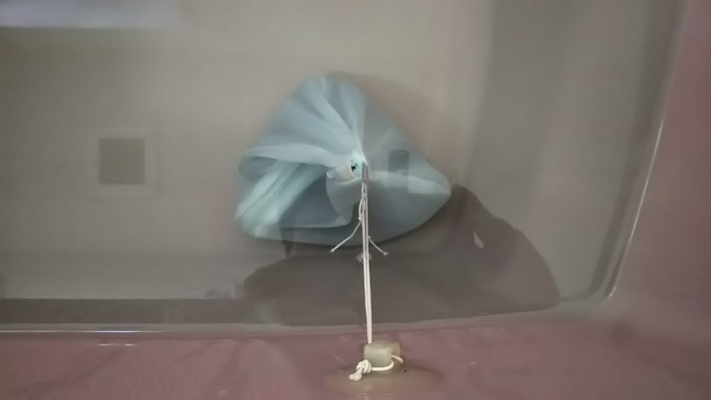 セラミックボールと備長炭を入れた網袋を湯船に入れる